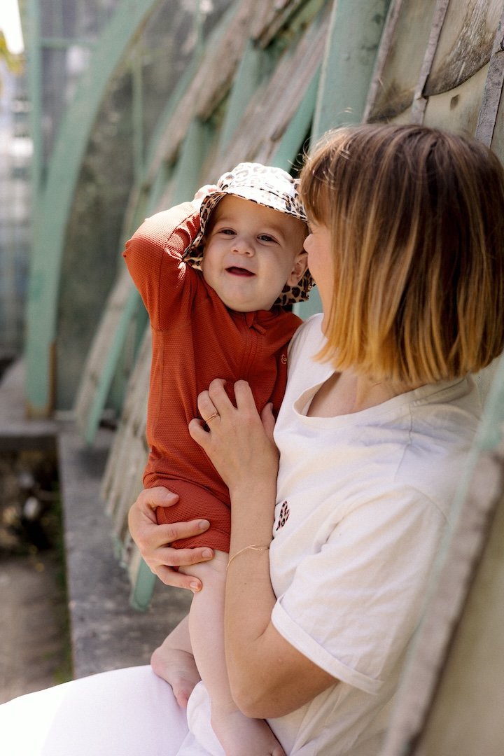 Bébé protégé par une combinaison de bain anti-UV terracotta